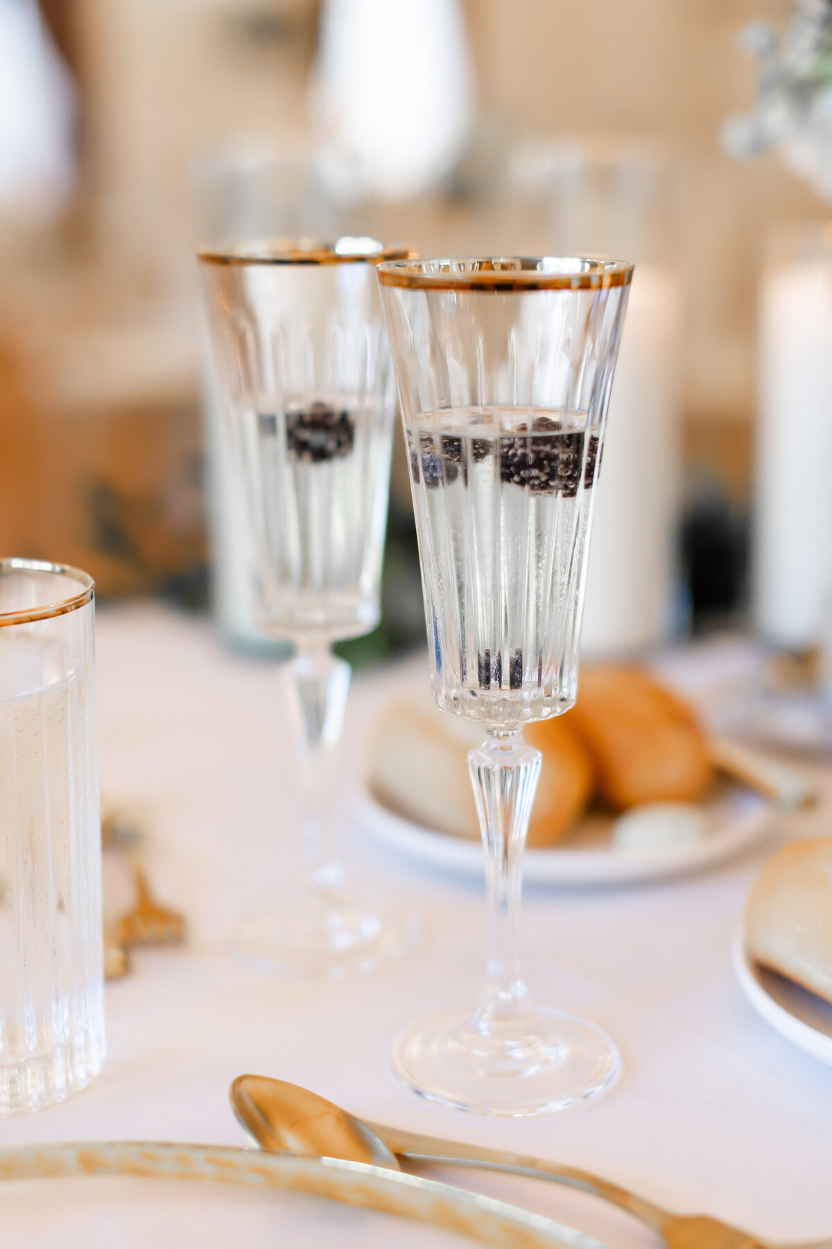 champagne glasses with blackberries in them at a wedding