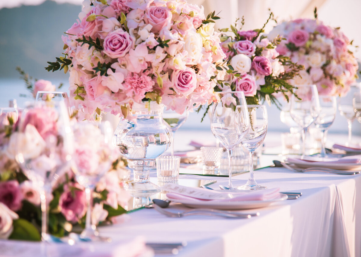 Table setting at a luxury wedding with beautiful pink flowers on the table.