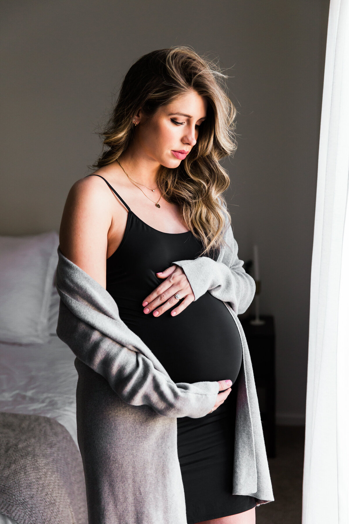 pregnant woman holding baby bump for at home lifestyle maternity photography session
