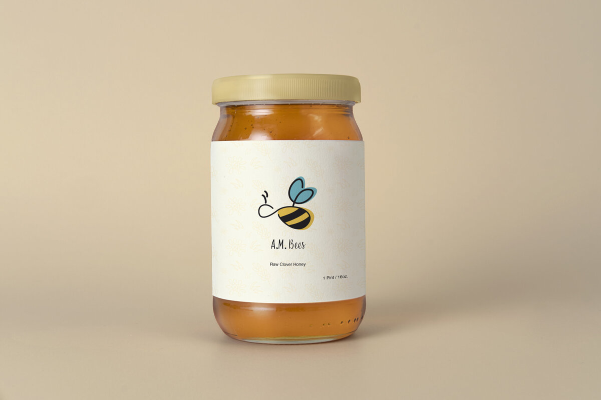 AM Bees logo created by Ayanna Richilano Designs on a jar of honey. The label is made up of the logo and brand pattern.