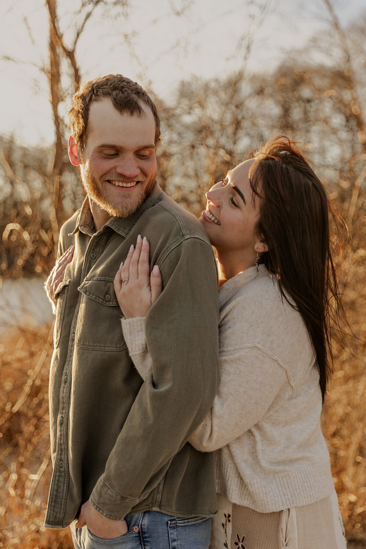 Soon to be wife hugging her fiance from behind captured by a Minnesota Couples Photographer