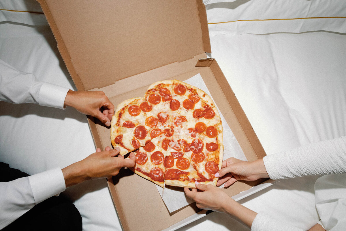 nyc-elopement-hands-holding-heart-shaped-pizza-at-plaza-hotel