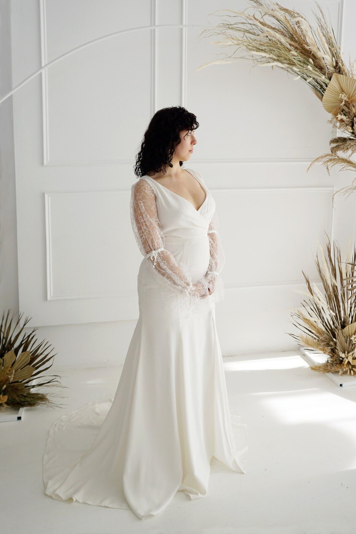Side front view of the Harlow style, which shows the v-neck bodice and fit-and-flare silhouette of the crepe wedding gown.