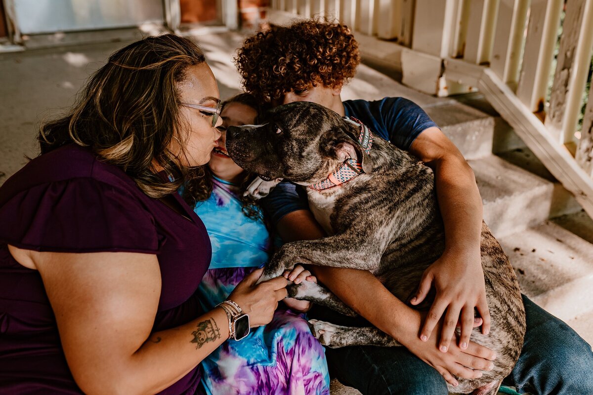 Family-Cuddles-With-Dog-on-Porch-Iowa-State-University-Ames-iowa-Storyteller-Collective-Photo-Co