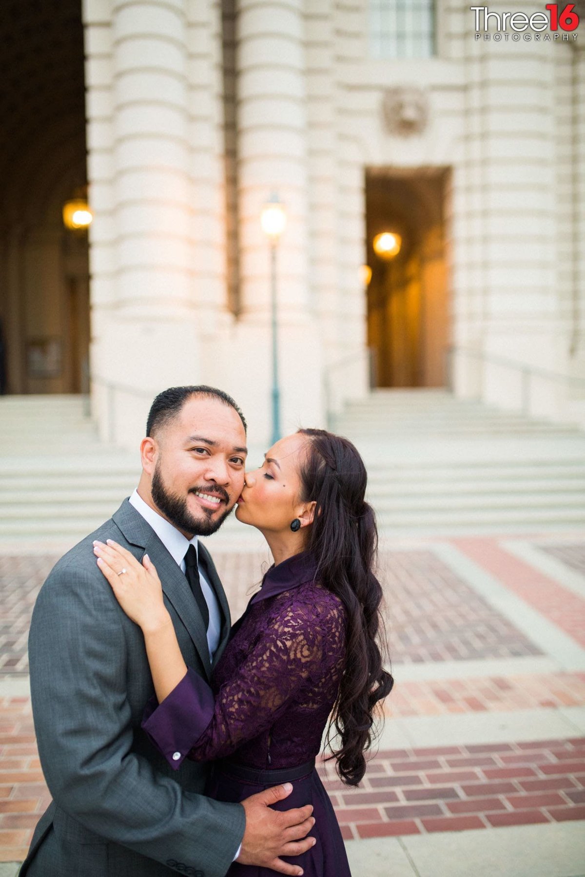 Bride to be kisses her Groom's cheek during engagement session