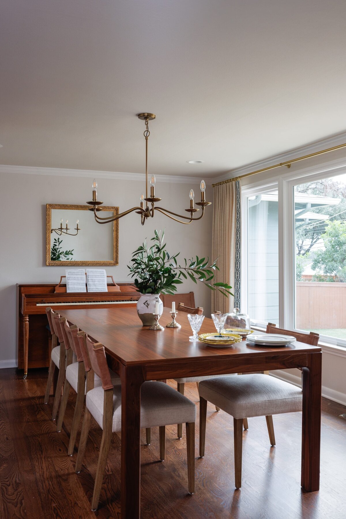 the keeping room interiors oakview dining room table with piano on wall with gold framed mirror