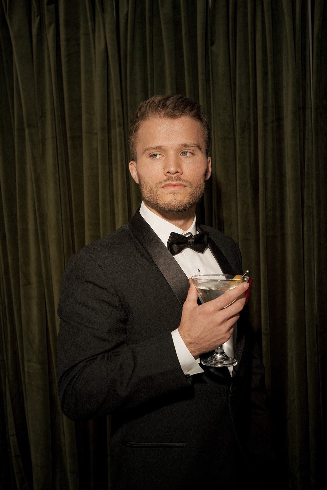 groom holding drink bow tie