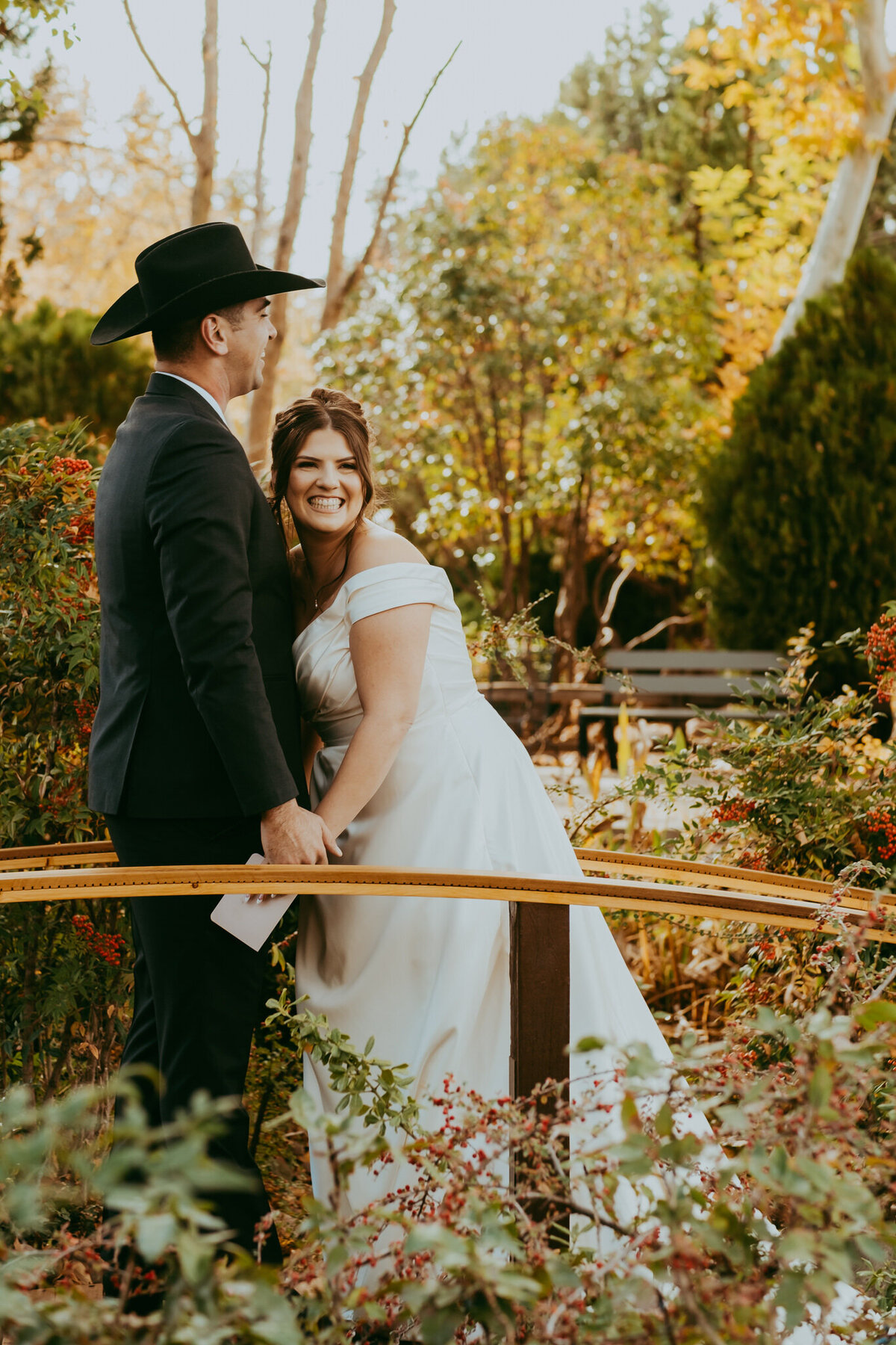 bride smiles during first look with groom on bridge