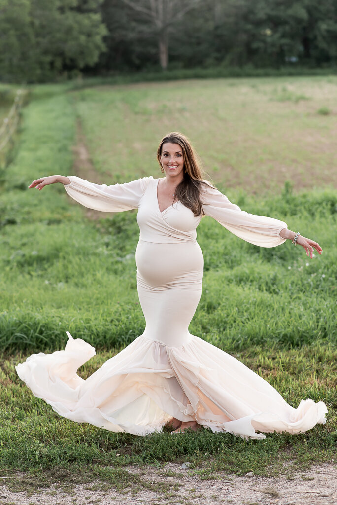 Pregnant mother in white dress with dress blowing all around her | Sharon Leger Photography | CT Newborn & Family Photographer | Canton, Connecticut