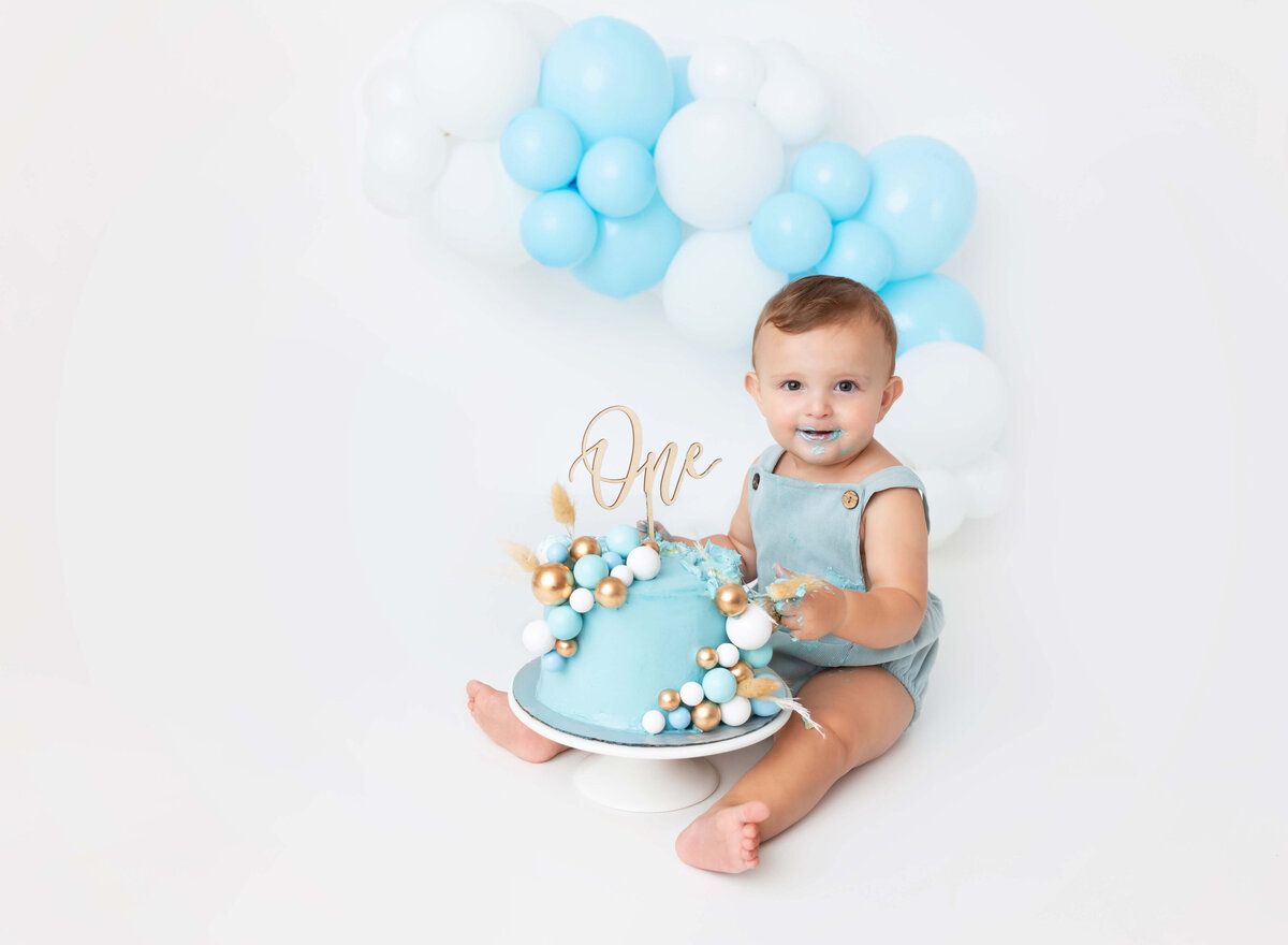 1st birthday cake smash photoshoot in New York City with vibrant balloon garlands and playful decorations. A fun and professional session to capture special moments for your baby’s first birthday celebration