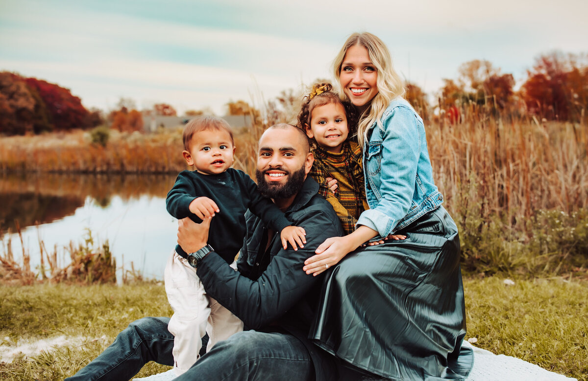 family looking at camera, sitting by the lake, perrysburg preserve park , metro park in toledo, sunset