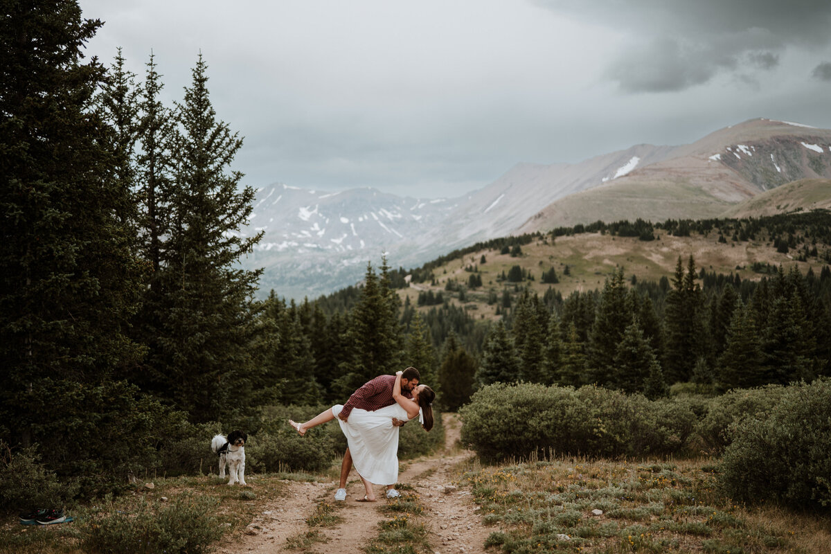 Romantic mountain kiss on a Hoosier Pass trail with couple and dog during elopement.