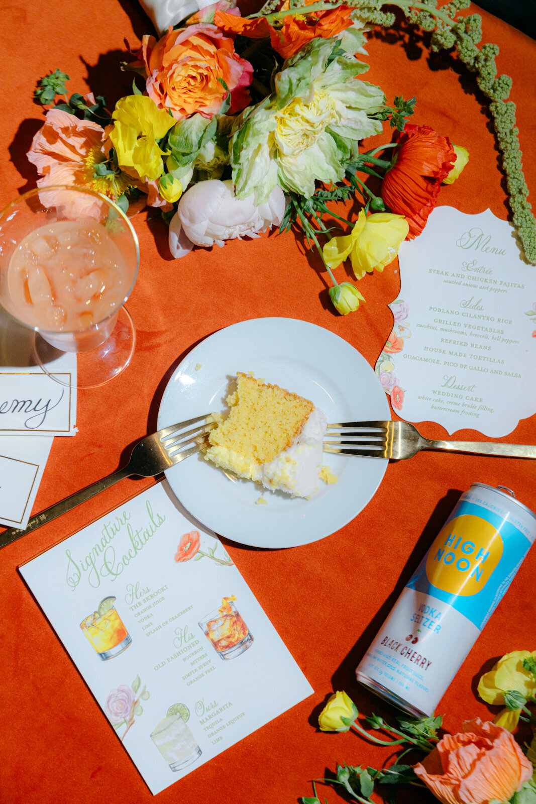 Bright and bold modern wedding reception details with cake, flowers, invitation, and drinks