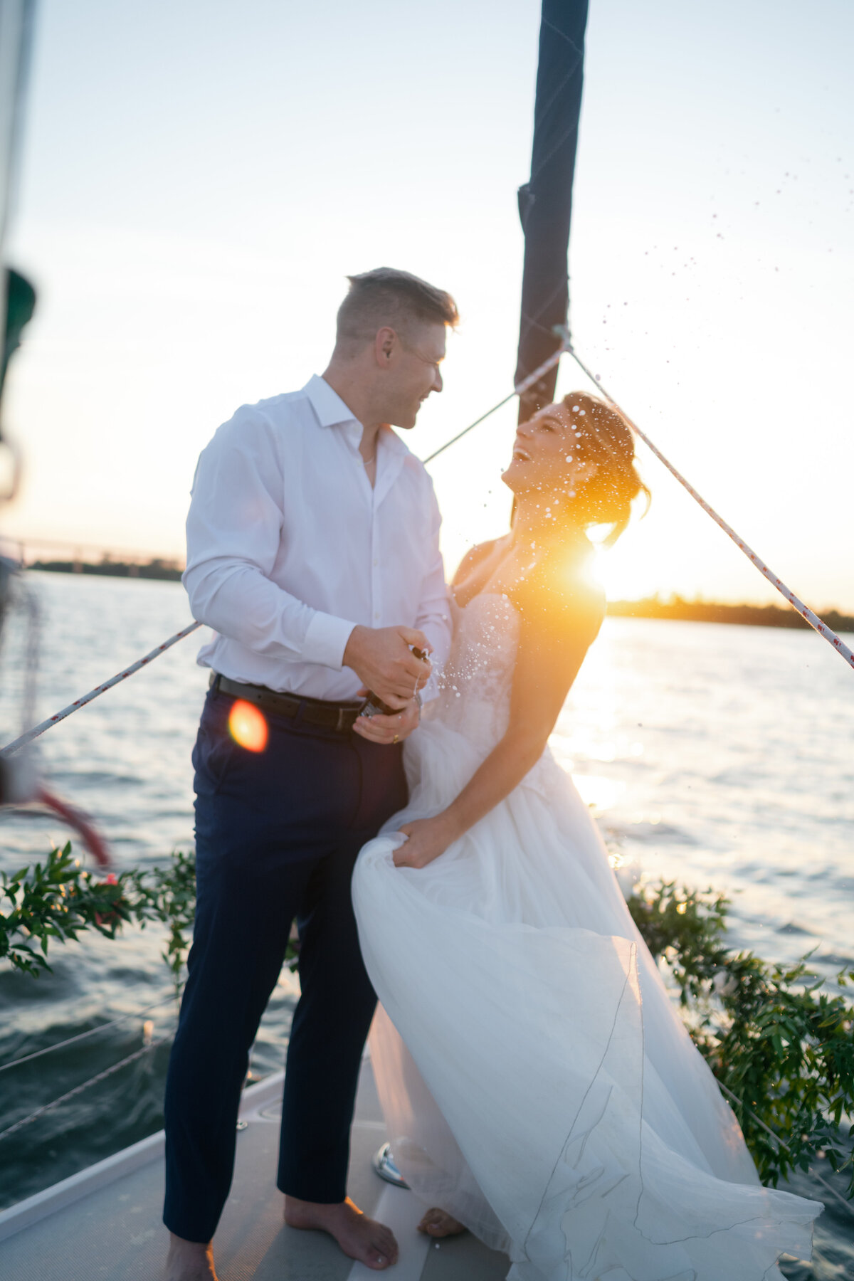 Bride and groom embrace in front of pastel rose wall