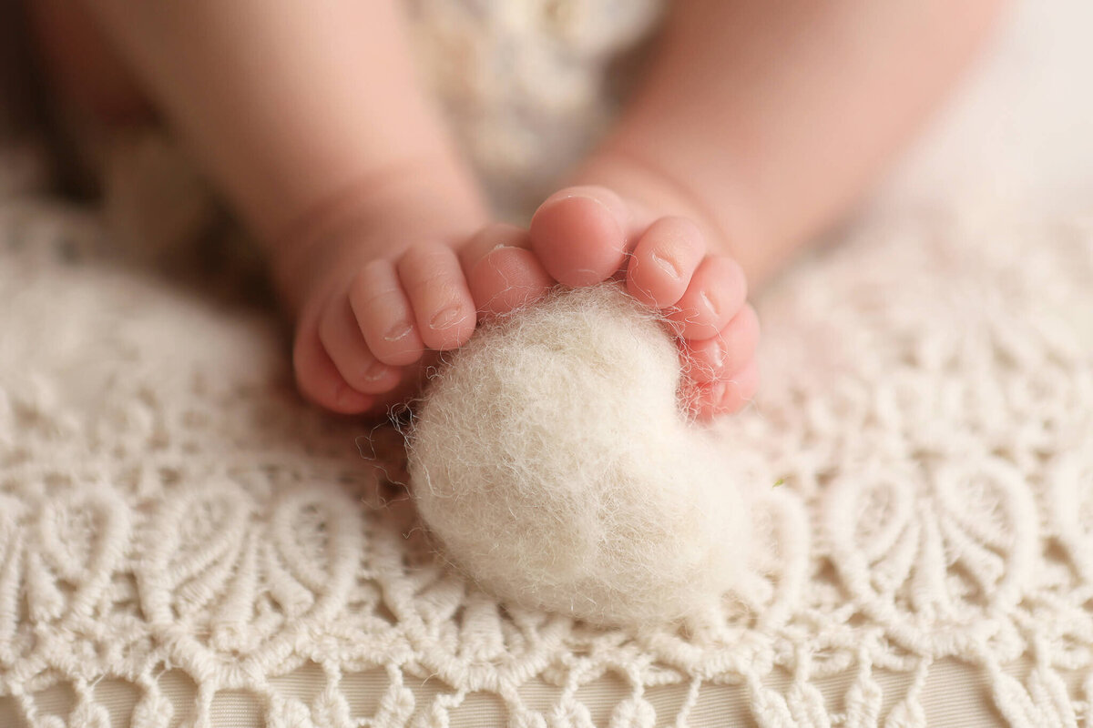 Newborn toes hugging a heart during her newborn photography session.