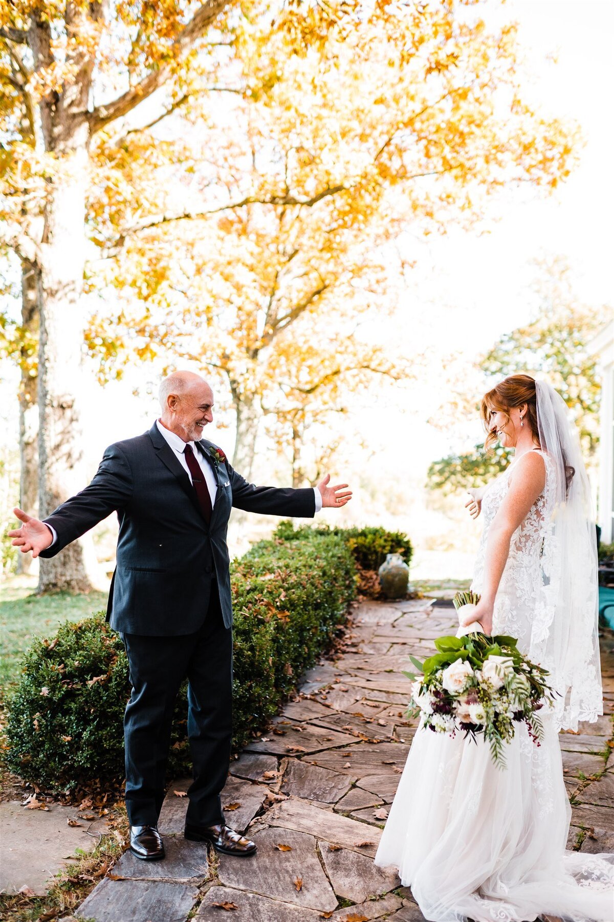 first look between father of the bride and bride at Richmond wedding venues patio space with father holdin gout his arms in excitement while the bride smiles and shows her dress to her dad for a sentimental and candid wedding photo
