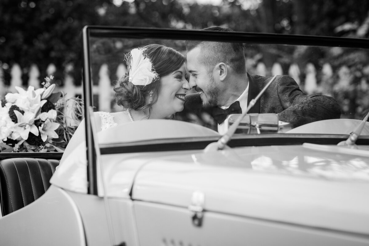 1920 Gatsby wedding at The Thompson House & Gardens - bride and groom nuzzle in antique car