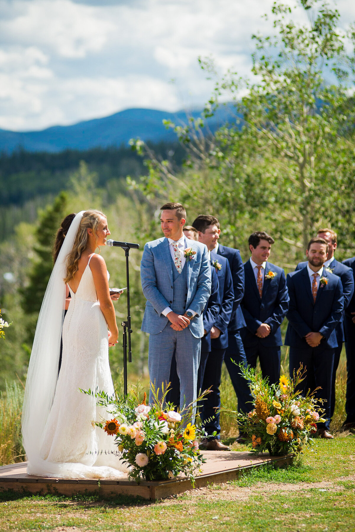 A bride and groom look out into the crowd during their outdoor wedding ceremony in Denver, Colorado.