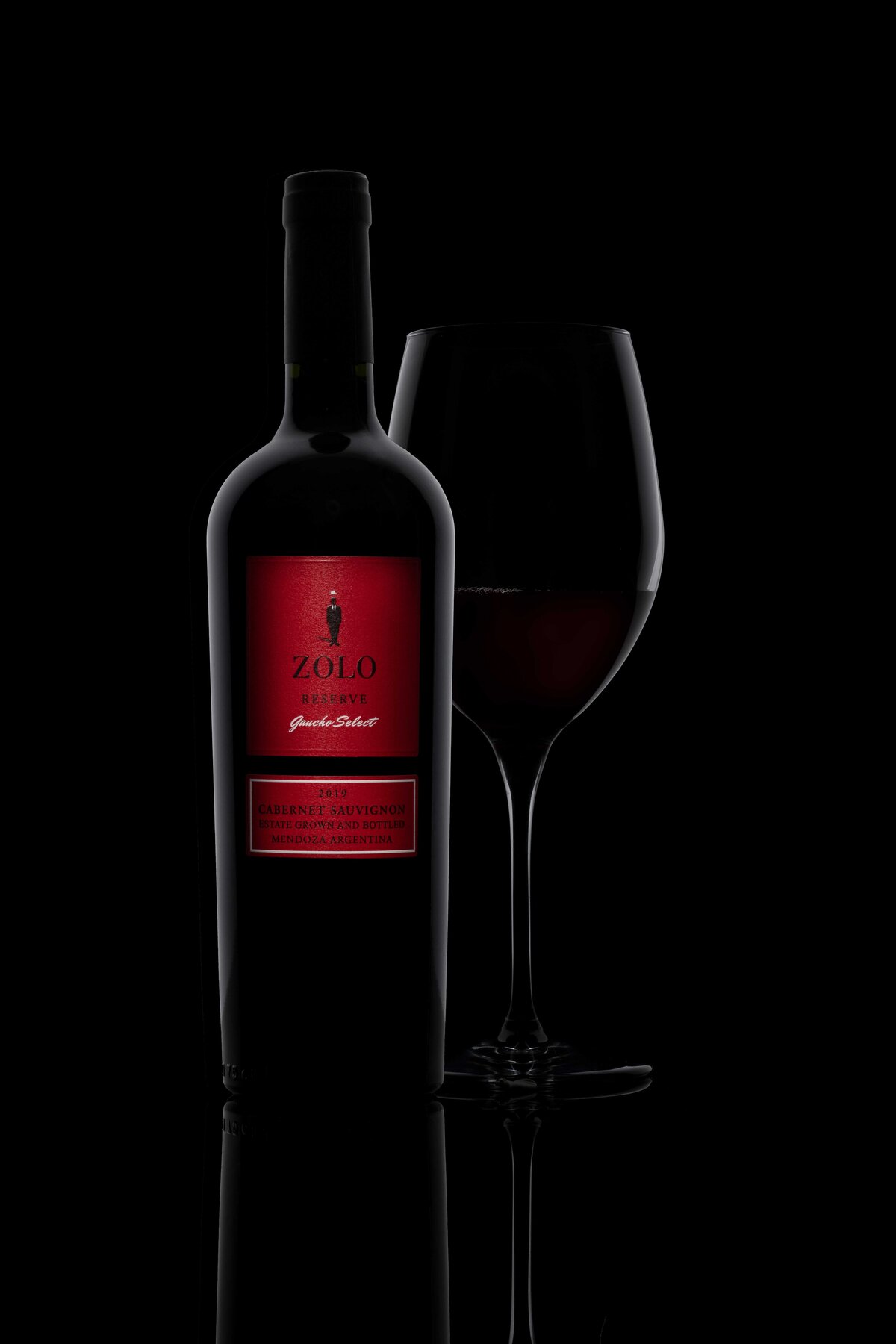 A bottle of Zolo Reserve with artistic lighting against black backdrop
