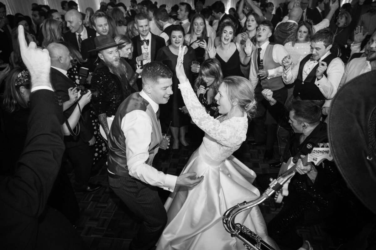 Bride and groom partying hard on the dancefloor with their guests and a live band