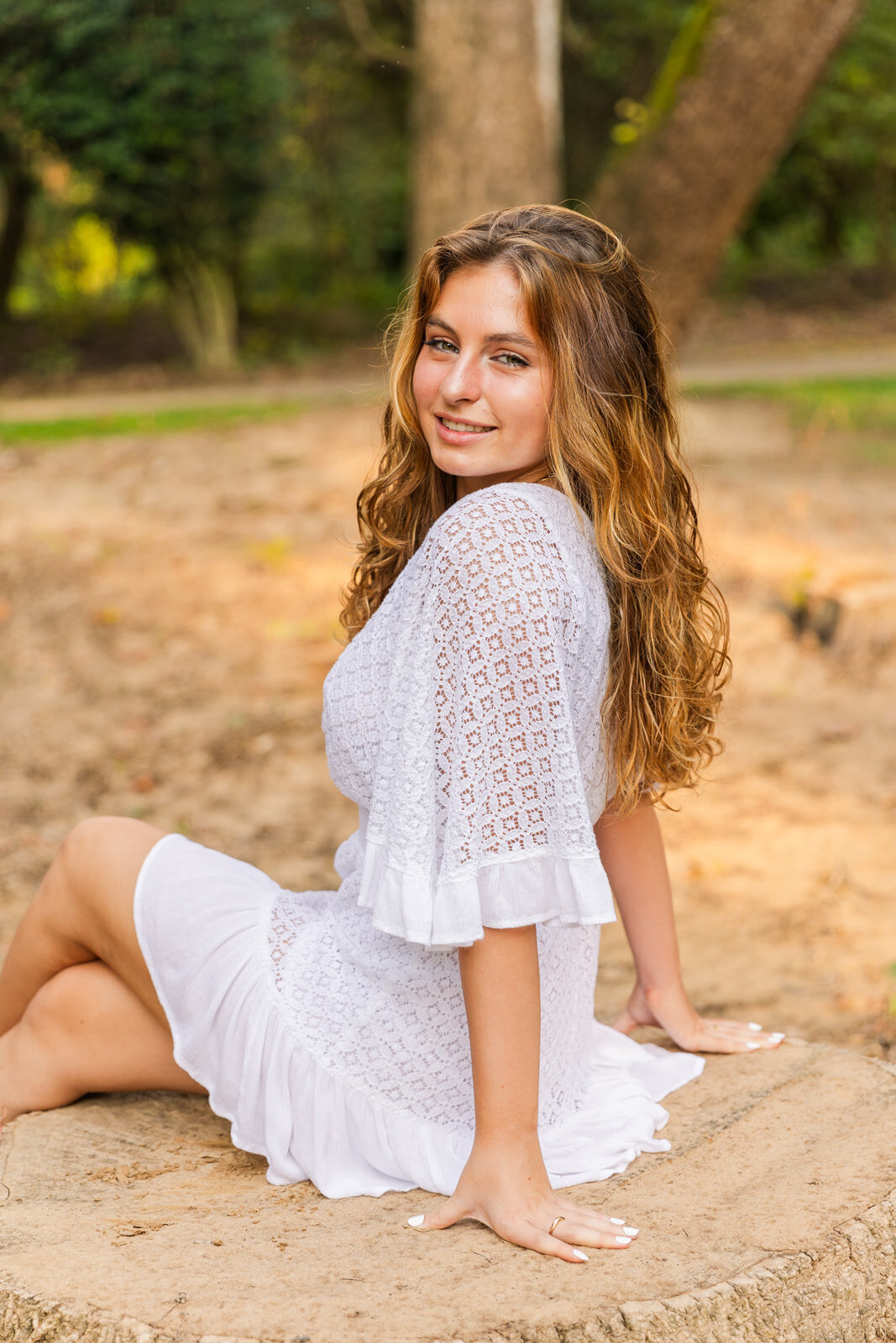 senior girl sitting and looking at the camera over her shoulder during portraits photo session