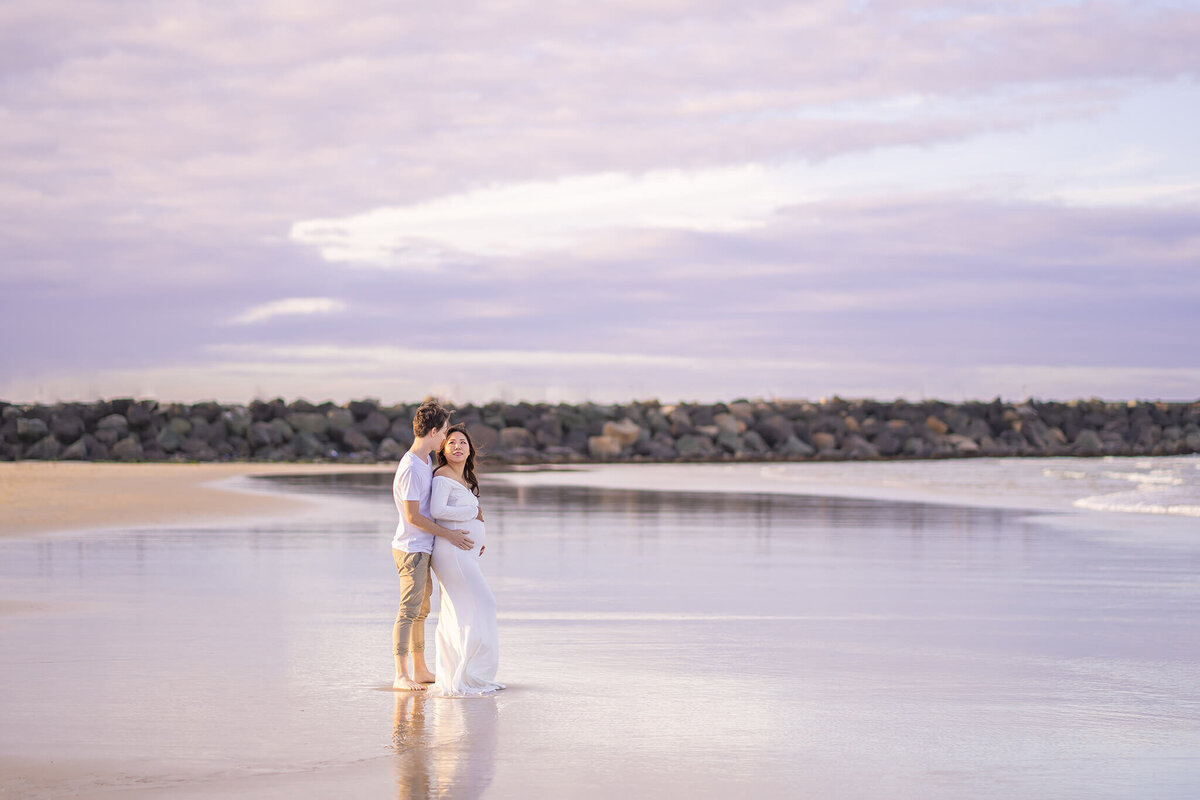 Pregnancy photoshoot in water with pastel sunset colours in Gold Coast QLD