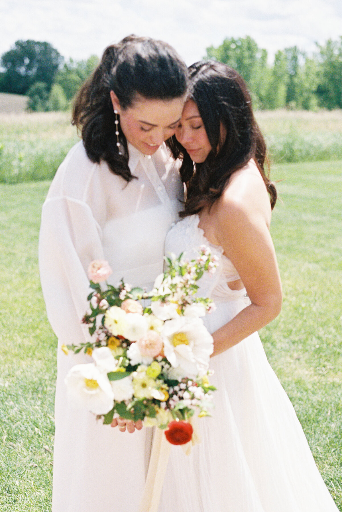 same sex couple holding bouquet