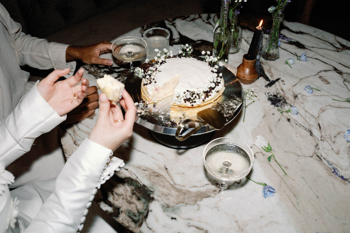 NYC city hall elopement photographer couple eating crepe cake with champagne wearing viktor rolf mariage dress
