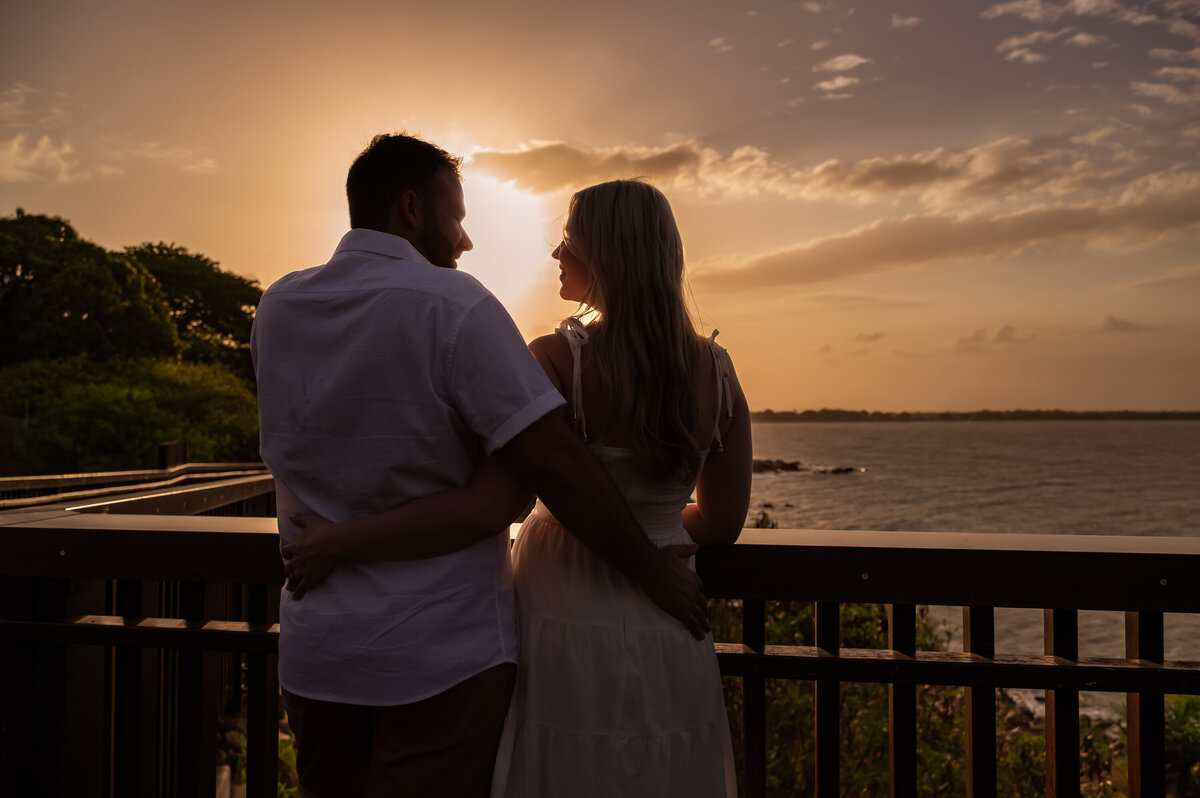 man and woman at a lookout looking at each other as the sun sets - Townsville Engagement Photography by Jamie Simmons