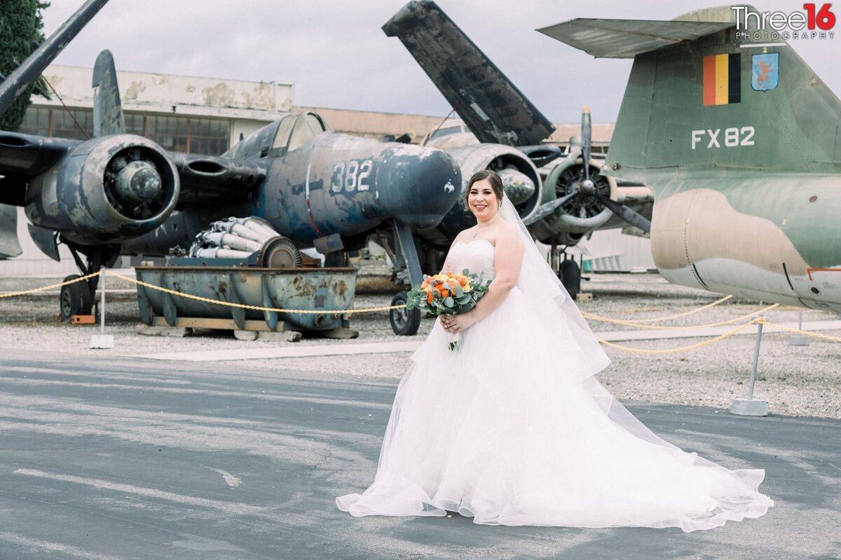 Bride poses for photos in front of a vintage war plane