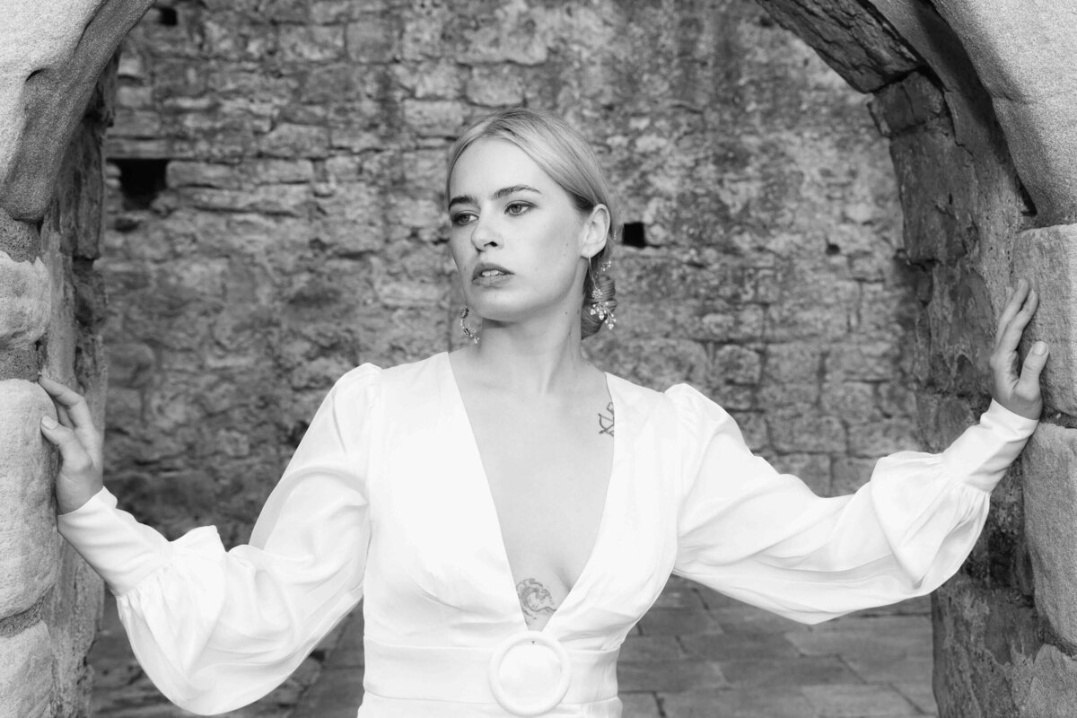 A very cool bride with open chest dress stares past the camera 