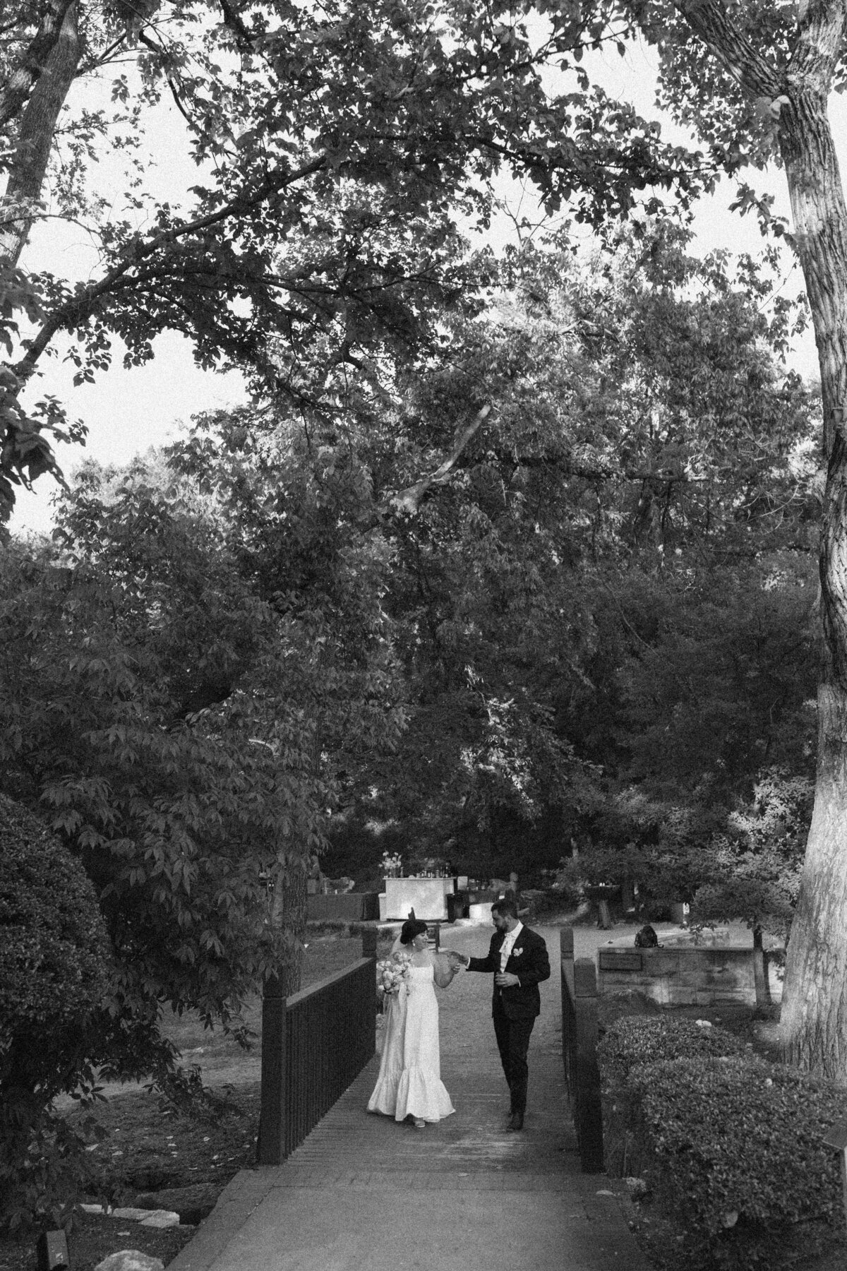 Bride and groom walking through the gardens at Umlauf Sculpture Garden, Austin