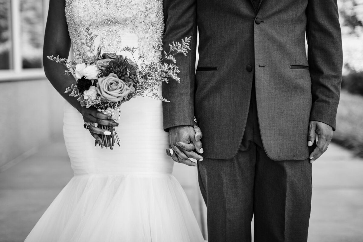 bride in gown and groom in suit holding hands