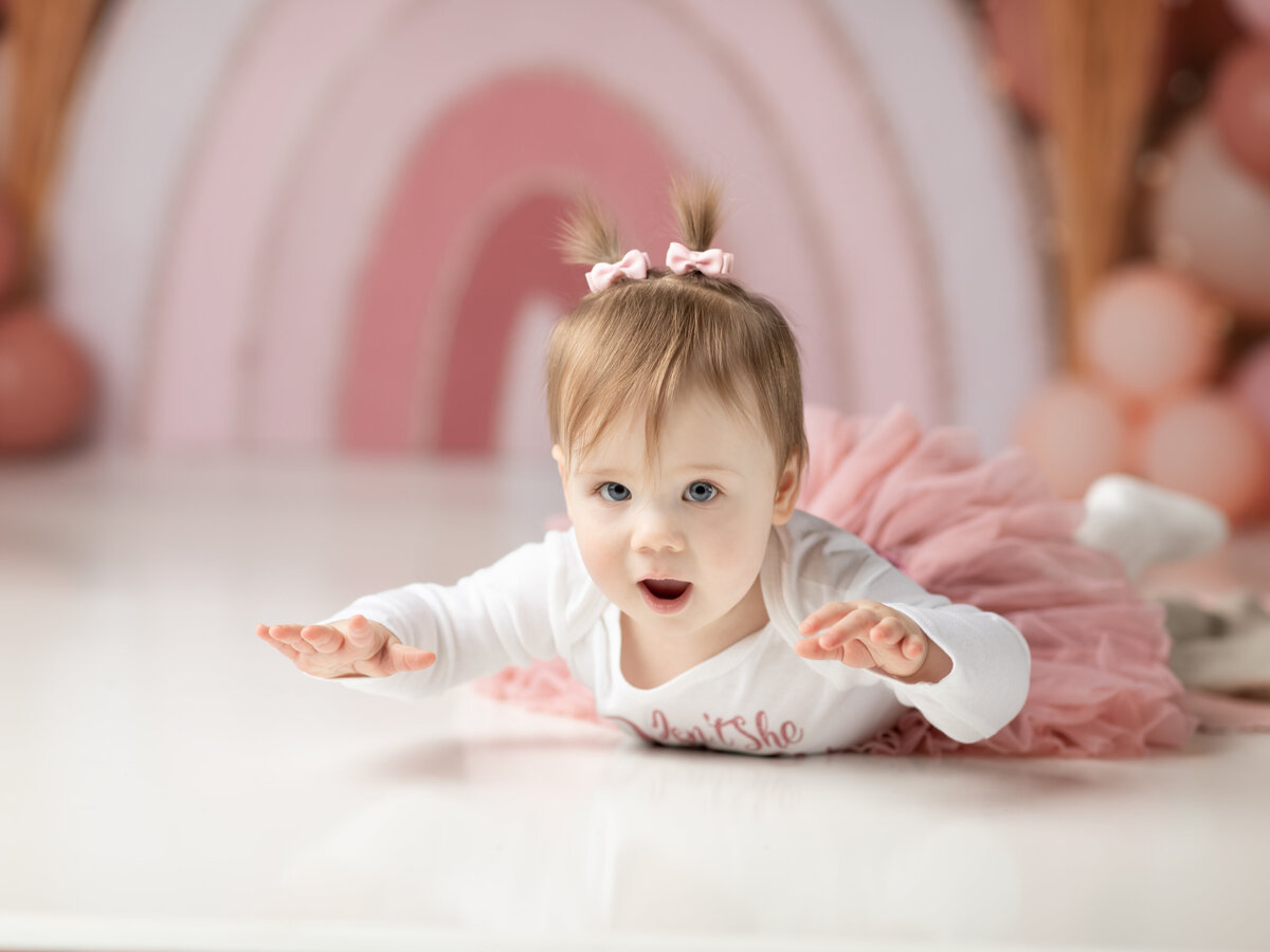 one year old girl in pink and white tutu for first birthday photoshoot