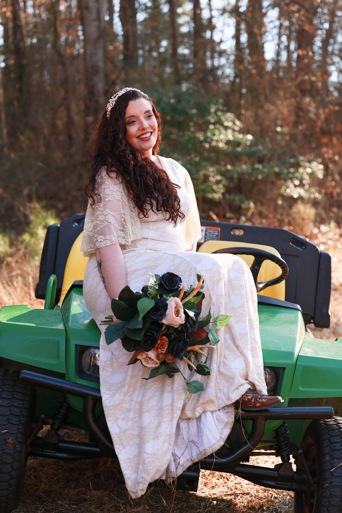 bride wearing lace dress and cowgirl boots sitting on John Deere tractor in Hamilton Georgia by Columbus Georgia wedding photographer Amanda Richardson Photography
