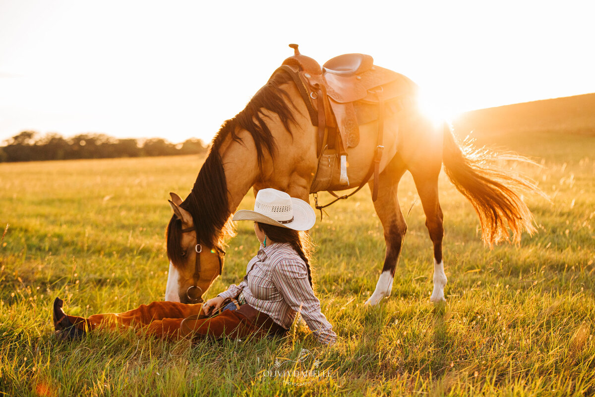 girl sitting with horse at sunset