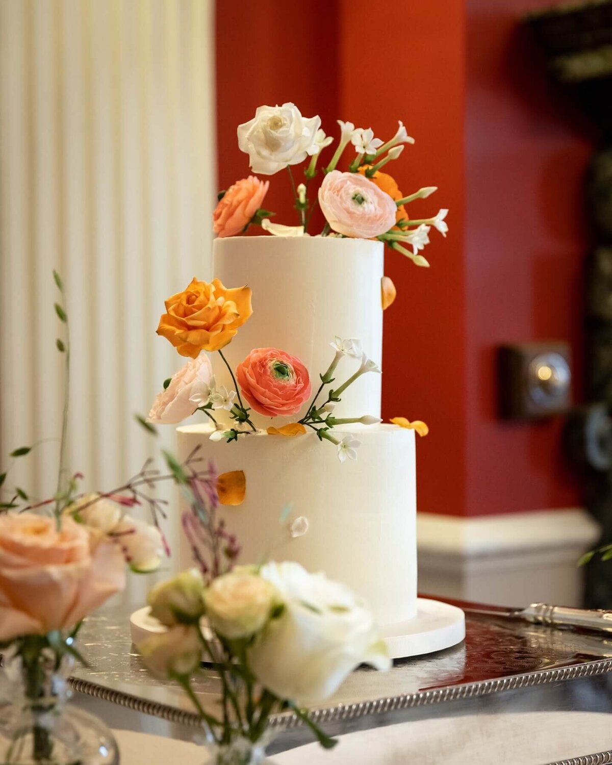 a large two tier cake with sugar flowers