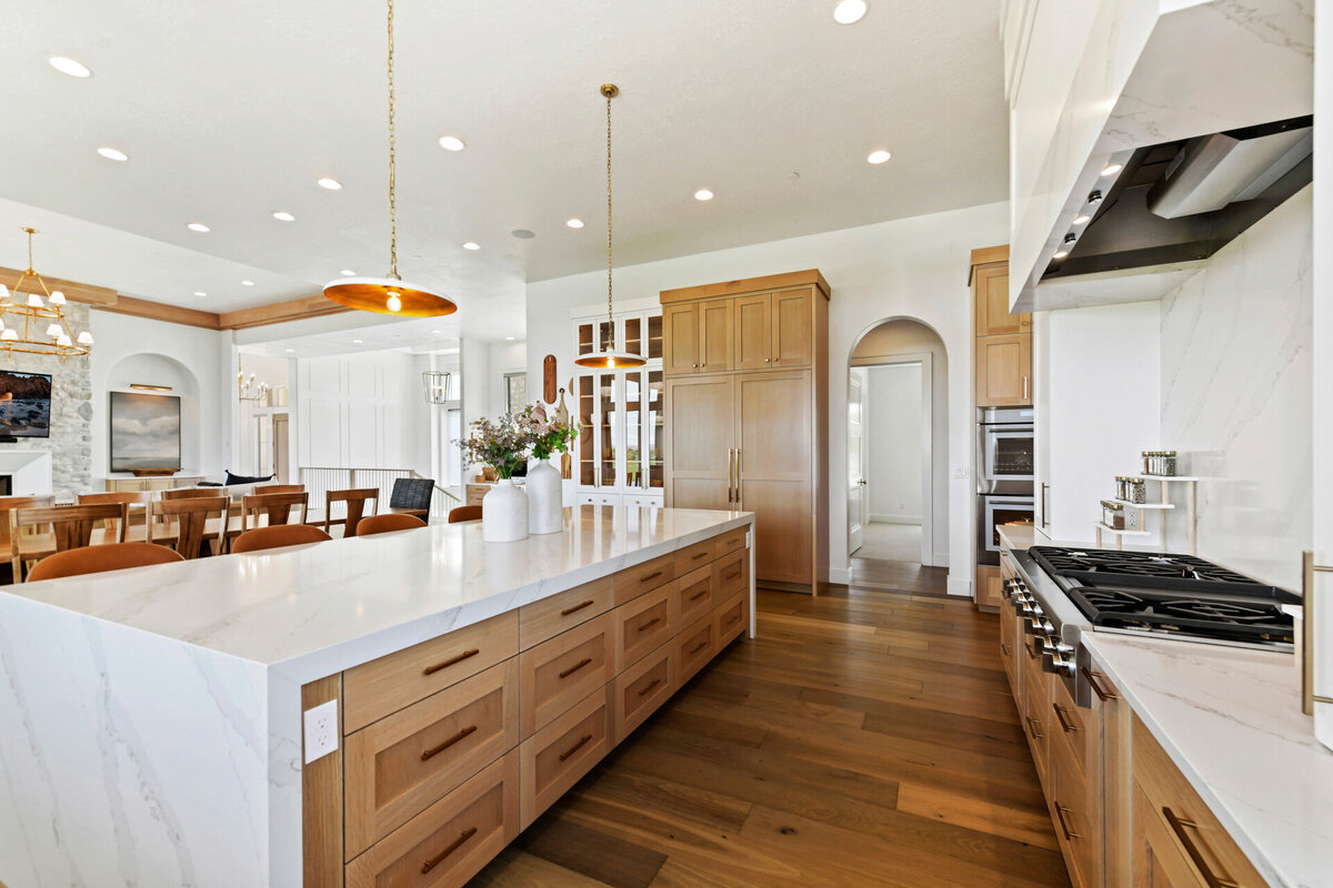Custom kitchen design with hardwood floors, statement lighting, and luxury cabinetry by Idaho luxury custom home builder Thompson Homes