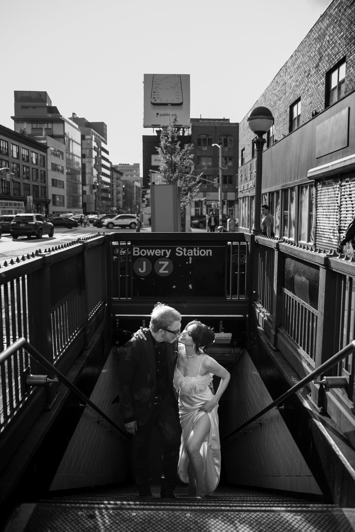 A bride and groom kiss on the stairs down to the Bowery subway station in Manhattan