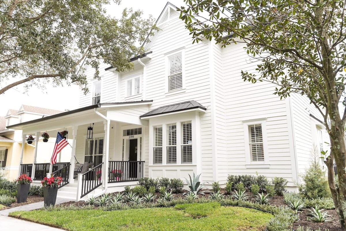 dewine design orlando interior designer modern lakehouse exterior house with white siding and black pourch railing