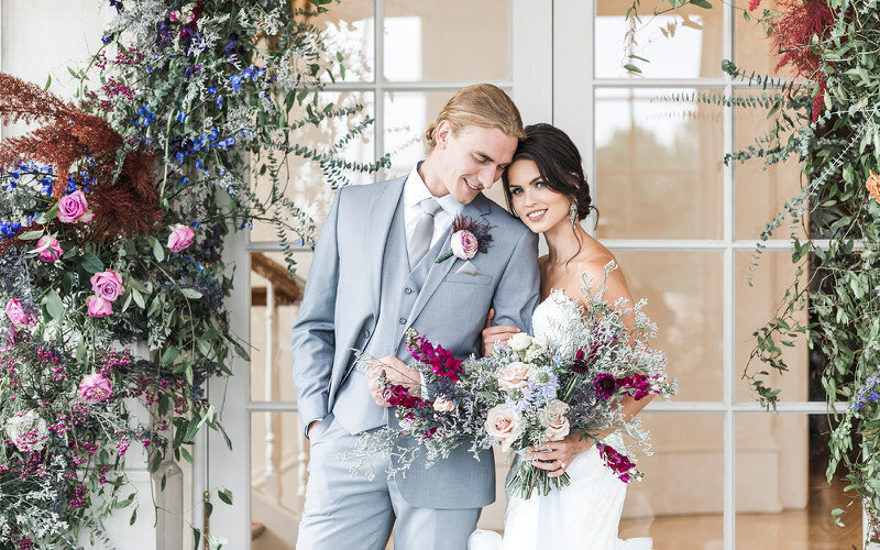 Bride and groom walk in ocean side garden at Whispering Rose Ranch at sunset