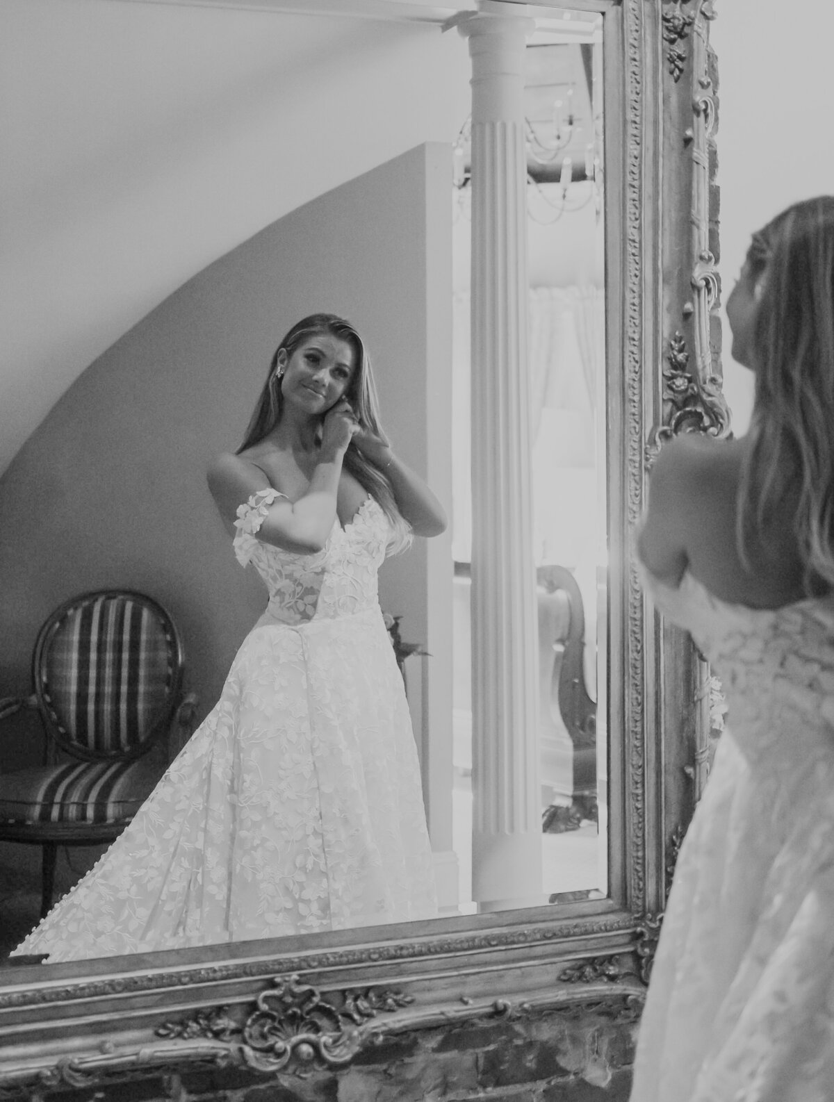 bride looking in the mirror fixing her earrings at Dr Phillips House in Orlando Florida by Orlando Wedding Photographer Amanda Richardson Photography