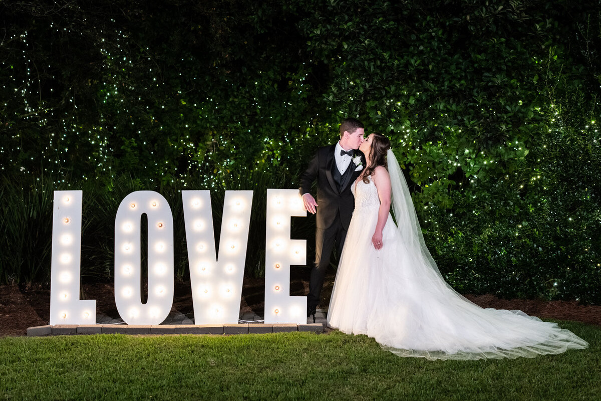 Couple kissing by Southern Oaks love sign