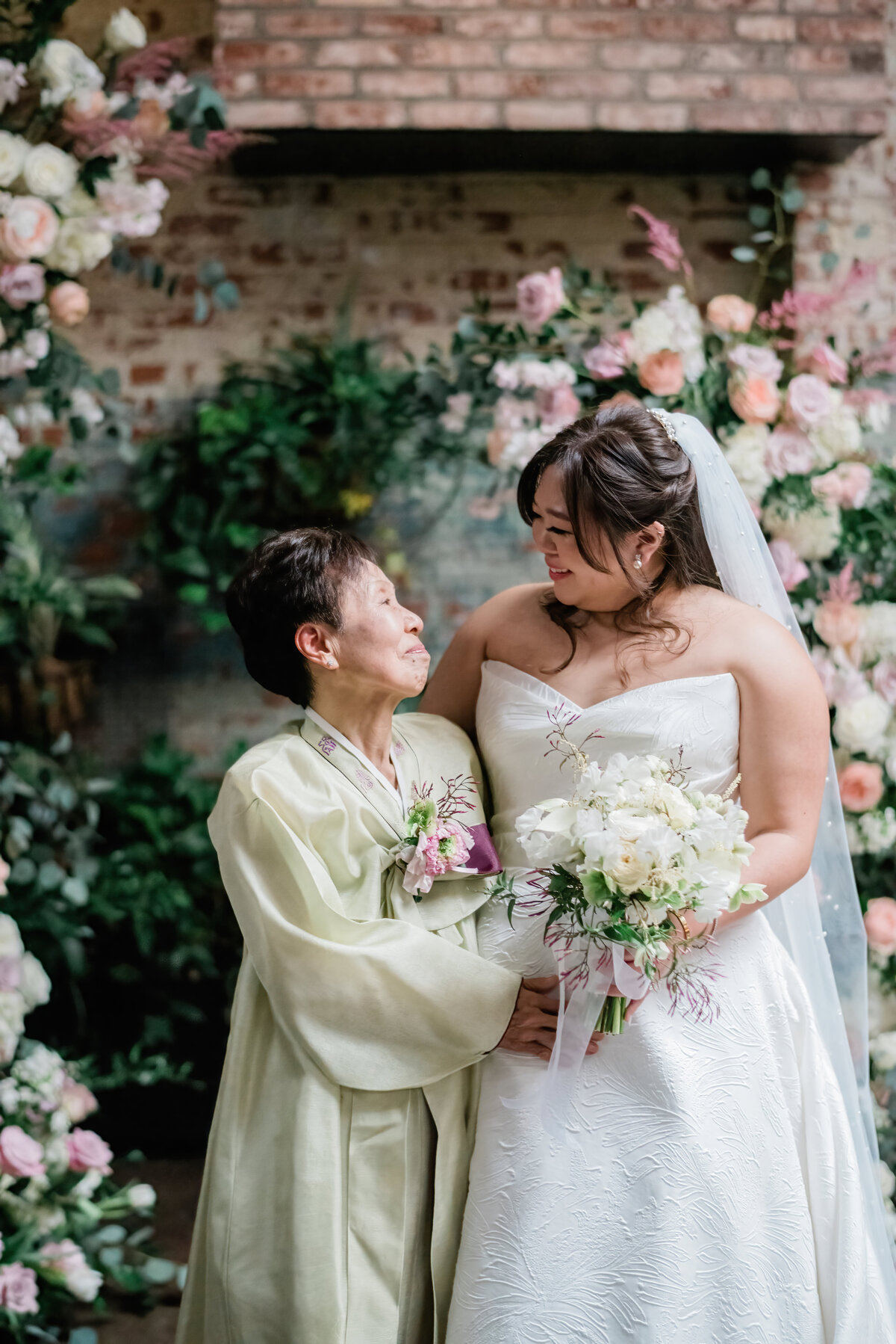 Bride and her grandmother smile while holding each other