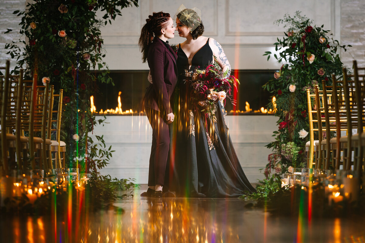 Two brides smiling at the wedding alter