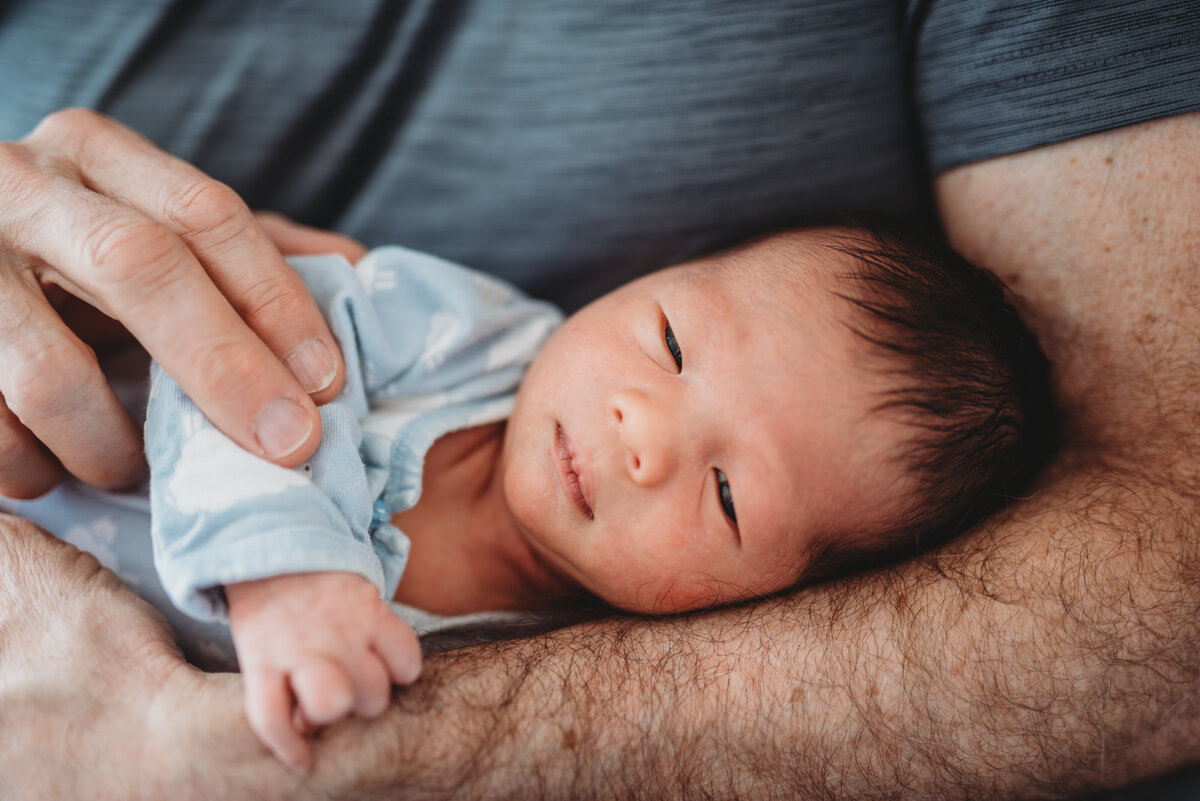 A tender moment between a newborn and parent, captured in a warm and intimate lifestyle newborn photography session in Connecticut. Preserve the beauty of these first precious days with natural, in-home newborn photography.