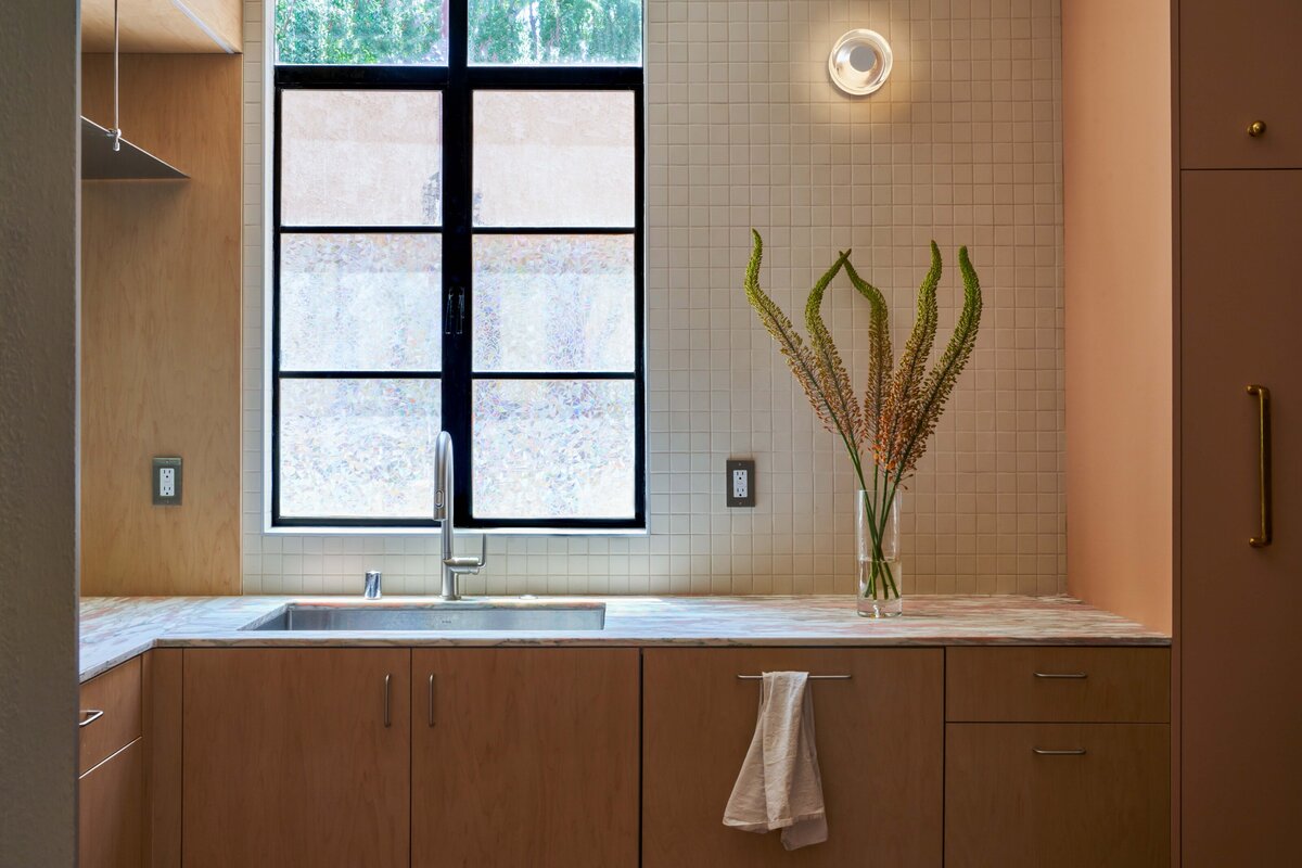 Southern California kitchen remodel galley kitchen renovation modern organic kitchen design Norwegian Rose marble countertop maple plywood kitchen cabinets stainless steel floating shelf porcelain 2x2 mosaic tile Saltillo breeze blocks modern kitchen storage solutions SoCal interior design organic modern kitchen kitchen design with natural light thoughtful floor plan edits custom pullout pantry contemporary galley kitchen