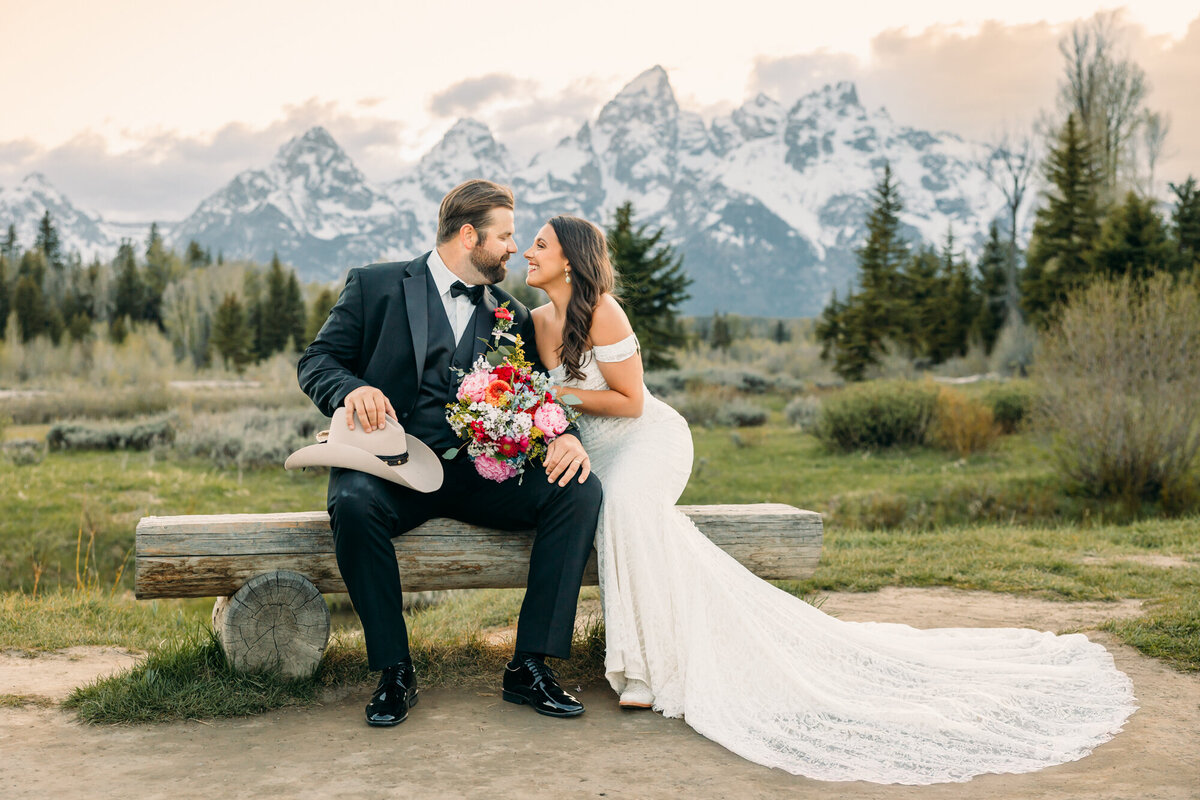 Jackson Hole wedding and elopement bride and groom with cowboy hat and pink florals