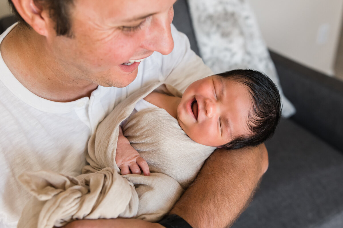 dad holding baby in Scottsdale lifestyle newborn photography session