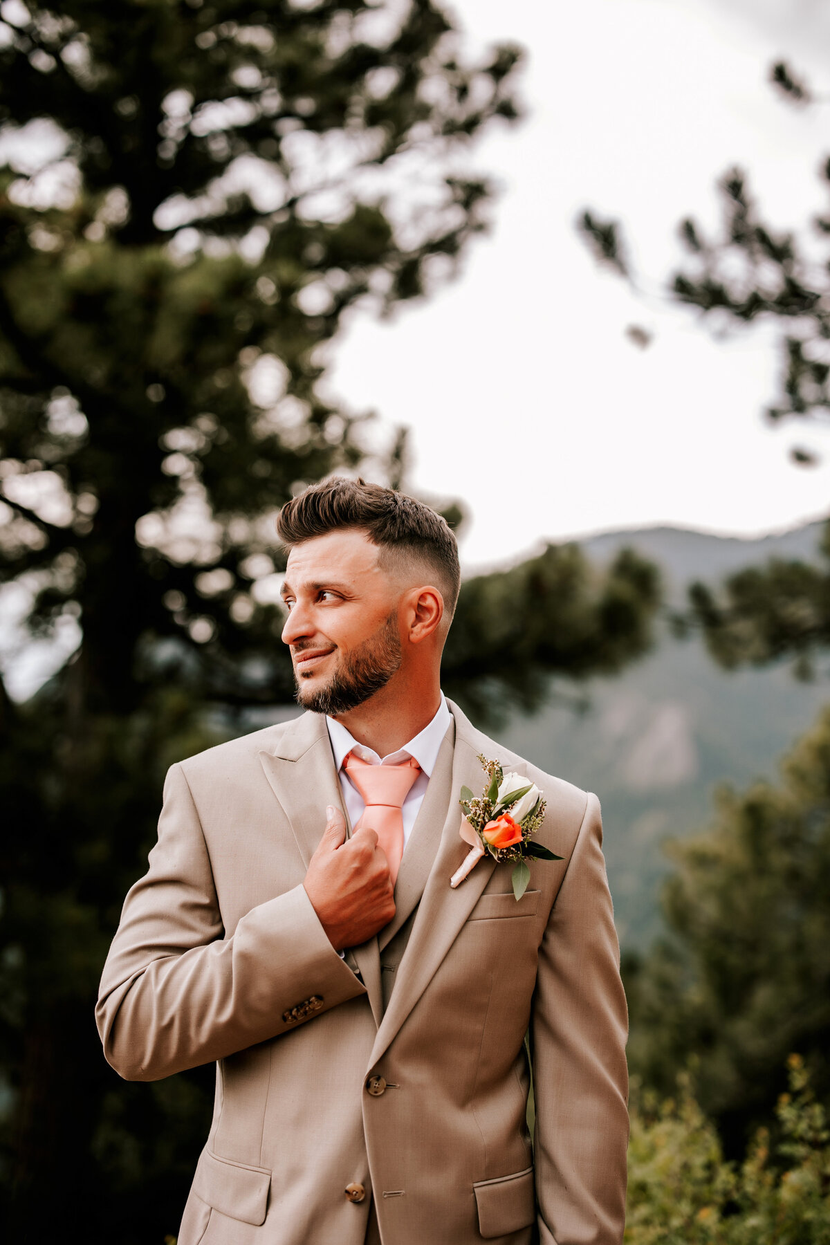 Husband in a tan suit holding his collar waiting for his bride in Boulder, Colorado